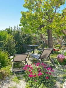 un grupo de sillas, una mesa y flores en Trulli Resort Aia Piccola en Alberobello