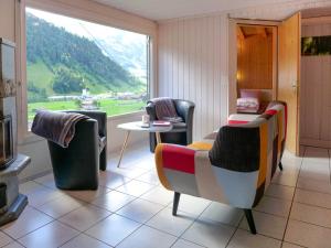 Zimmer mit Stühlen, einem Tisch und einem Fenster in der Unterkunft Holiday Home Chalet Guldeli by Interhome in Kandergrund