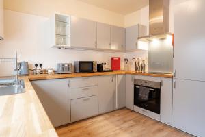 uma cozinha com armários brancos e um frigorífico em Great 3 bed Handbridge home - Sleeps 6 - EV Charger em Hough Green