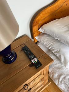 a bedside table with a lamp and a remote control on it at Woodville Lodge Guesthouse in Killarney