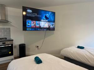 um quarto com uma televisão de ecrã plano na parede em Elegant Central Luton Studio - Contractors/Airport Travellers! em Luton