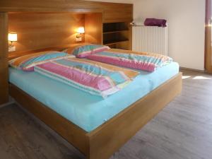 ein großes Bett mit zwei Kissen darüber in der Unterkunft Apartment Kammerlander - NKI135 by Interhome in Neukirchen am Großvenediger