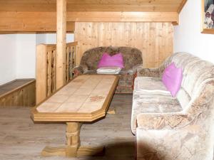 ein Wohnzimmer mit einem Holztisch und einem Sofa in der Unterkunft Apartment Kammerlander - NKI135 by Interhome in Neukirchen am Großvenediger
