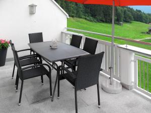 een tafel en stoelen op een balkon met een parasol bij Holiday Home Schiestl - MHO753 by Interhome in Ramsau im Zillertal