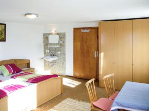 ein Schlafzimmer mit einem Bett und einem Tisch sowie ein Badezimmer in der Unterkunft Apartment Fiechter - FGZ350 by Interhome in Bruck am Ziller