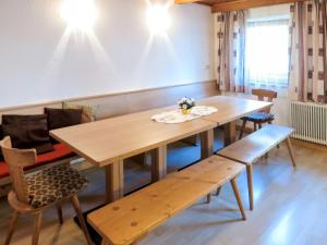 une salle à manger avec une table et des bancs en bois dans l'établissement Apartment Fiechter - FGZ350 by Interhome, à Bruck am Ziller