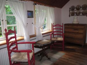 OberndorfにあるHoliday Home Hennevelt by Interhomeの赤い椅子、テーブル、窓が備わる客室です。