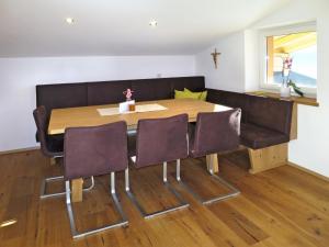 a dining room with a table and four chairs at Apartment Schoppengrub - BMG196 by Interhome in Bramberg am Wildkogel