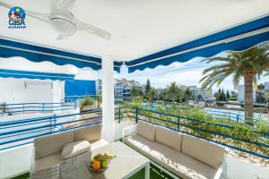 a balcony with a view of the ocean and palm trees at Apartamentos Fuente Sol Casa Azahar in Alcossebre