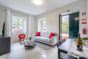a living room with a couch and a table at JMF House in São Vicente