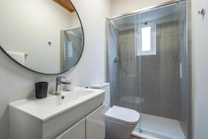 a bathroom with a shower and a sink and a mirror at JMF House in São Vicente +25 photos