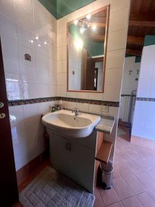 W łazience znajduje się umywalka i lustro. w obiekcie Home 26, near the lake w mieście Valmadrera