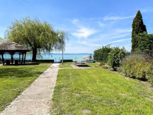 a path through a park with a gazebo and the ocean at Tóparti villa, közvetlen vízkapcsolattal in Siófok