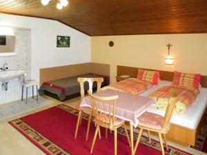 a bedroom with a bed and a table and a sink at Apartment Bloserhof by Interhome in Zellberg +18 photos