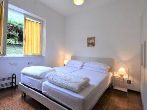 a bedroom with a bed with white sheets and a window at Apartment Villa Laura-3 by Interhome in Crone