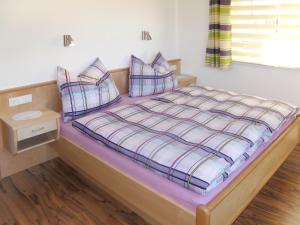 sypialnia z łóżkiem z fioletową pościelą i poduszkami w obiekcie Apartment Stefan - MHO686 by Interhome w mieście Hippach