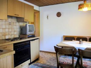 eine Küche mit einem Tisch und einem TV auf der Theke in der Unterkunft Apartment Schusterhäusl - MHO756 by Interhome in Schwendau