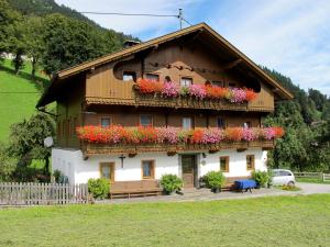 ein Haus mit Blumen auf der Seite in der Unterkunft Apartment Schusterhäusl - MHO756 by Interhome in Schwendau