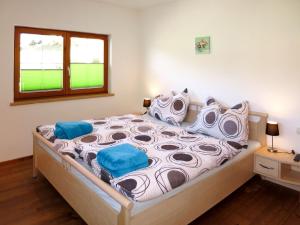 a bedroom with a large bed with blue pillows at Apartment Brix - BRG120 by Interhome in Bruck an der Großglocknerstraße