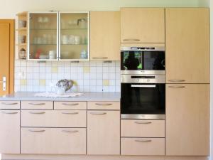 a kitchen with white cabinets and a black oven at Apartment Brix - BRG120 by Interhome in Bruck an der Großglocknerstraße