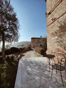 a table and chairs sitting next to a brick building at Pamperduto Country Resort in Porto Potenza Picena