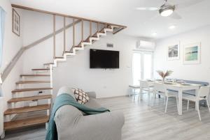 uma sala de estar branca com uma mesa de jantar e uma escadaria em Teljesen felújított, szépen berendezett nyaraló em Balatonfenyves