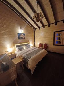 1 dormitorio con 1 cama grande, mesa y sillas en اكواخ الماريا en Arar