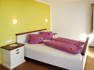 um quarto com uma cama com lençóis roxos e cor-de-rosa em Apartment Talmoosen-Bauer - BMG210 by Interhome em Bramberg am Wildkogel