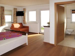 um quarto com uma cama, uma cadeira e um WC em Apartment Talmoosen-Bauer - BMG210 by Interhome em Bramberg am Wildkogel