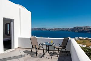 a patio with a table and chairs on a balcony at Pancratium Villas & Suites in Akrotiri
