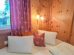 a bedroom with a bed with white pillows and a window at Chalet Wegscheider by Interhome in Mayrhofen +32 photos
