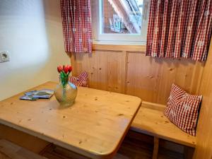a wooden table with a vase of flowers on it at Chalet Wegscheider by Interhome in Mayrhofen
