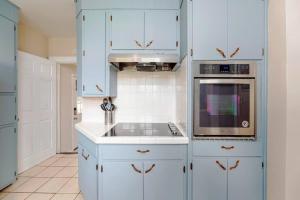 uma cozinha branca com armários azuis e um lavatório em 'My Tennessee Mountain Home' in Kingsport em Kingsport