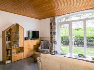 a living room with a large window and a chair at Apartment von Dollen-1 by Interhome in Oberndorf