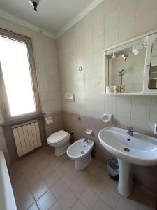 a white bathroom with a sink and a toilet at Attico Zamagna in Cesenatico +42 photos