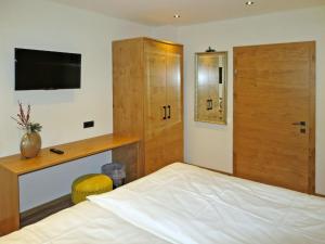 フューゲンにあるApartment Apart Bergart - FGZ143 by Interhomeのベッドルーム1室(ベッド1台、壁掛けテレビ付)