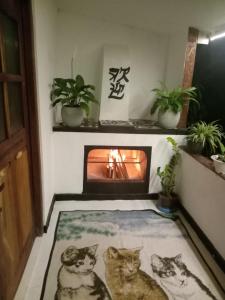 ein Wohnzimmer mit einem Kamin mit drei Katzen auf einem Teppich in der Unterkunft Diyathalawa The Mountain Lodge in Ellealutwela