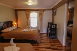 a bedroom with two beds and a window at Tunupa Lodge Hotel in Ollantaytambo
