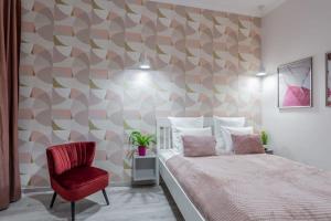 ein Schlafzimmer mit einem Bett und einem roten Stuhl in der Unterkunft Gorgeous & Super Central Studio in Budapest