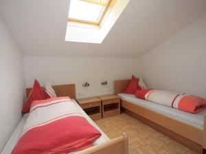 2 Betten in einem kleinen Zimmer mit Dachfenster in der Unterkunft Apartment Gasteighof-2 by Interhome in Kapfing