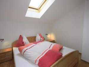 Schlafzimmer mit einem Bett mit roten und weißen Kissen in der Unterkunft Apartment Gasteighof-2 by Interhome in Kapfing