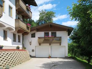 a house with a balcony and two garage doors at Holiday Home Margit - MHO786 by Interhome in Hippach