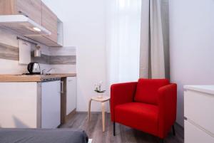een rode stoel in een kleine kamer met een keuken bij New comfy studio at convenient location in Boedapest