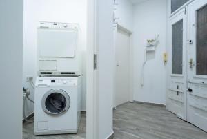 een witte wasruimte met een wasmachine en droger bij New comfy studio at convenient location in Boedapest