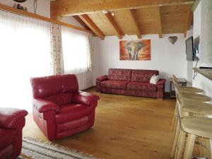 uma sala de estar com um sofá vermelho e uma mesa em Apartment Nachbarbauer - LFE120 by Interhome em Lofer