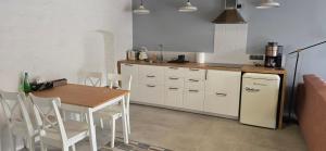 a kitchen with a table and a table and a refrigerator at Apartamenty STARA PIEKARNIA in Płock