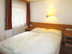 シュトゥンムにあるApartment Lechners Wohnwelt - SUZ374 by Interhomeのベッドルーム1室(白いベッド1台、ランプ、窓付)