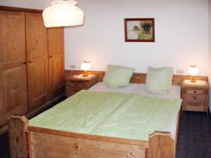 1 dormitorio con 1 cama de madera y 2 mesitas de noche en Apartment Josef - ZAZ590 by Interhome en Aschau