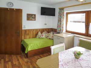 Un pequeño dormitorio con una cama verde y una mesa en Apartment Brugger - MHO546 by Interhome, en Ramsau im Zillertal