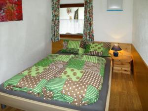 1 dormitorio con 1 cama con sábanas verdes y marrones en Apartment Brugger - MHO546 by Interhome, en Ramsau im Zillertal